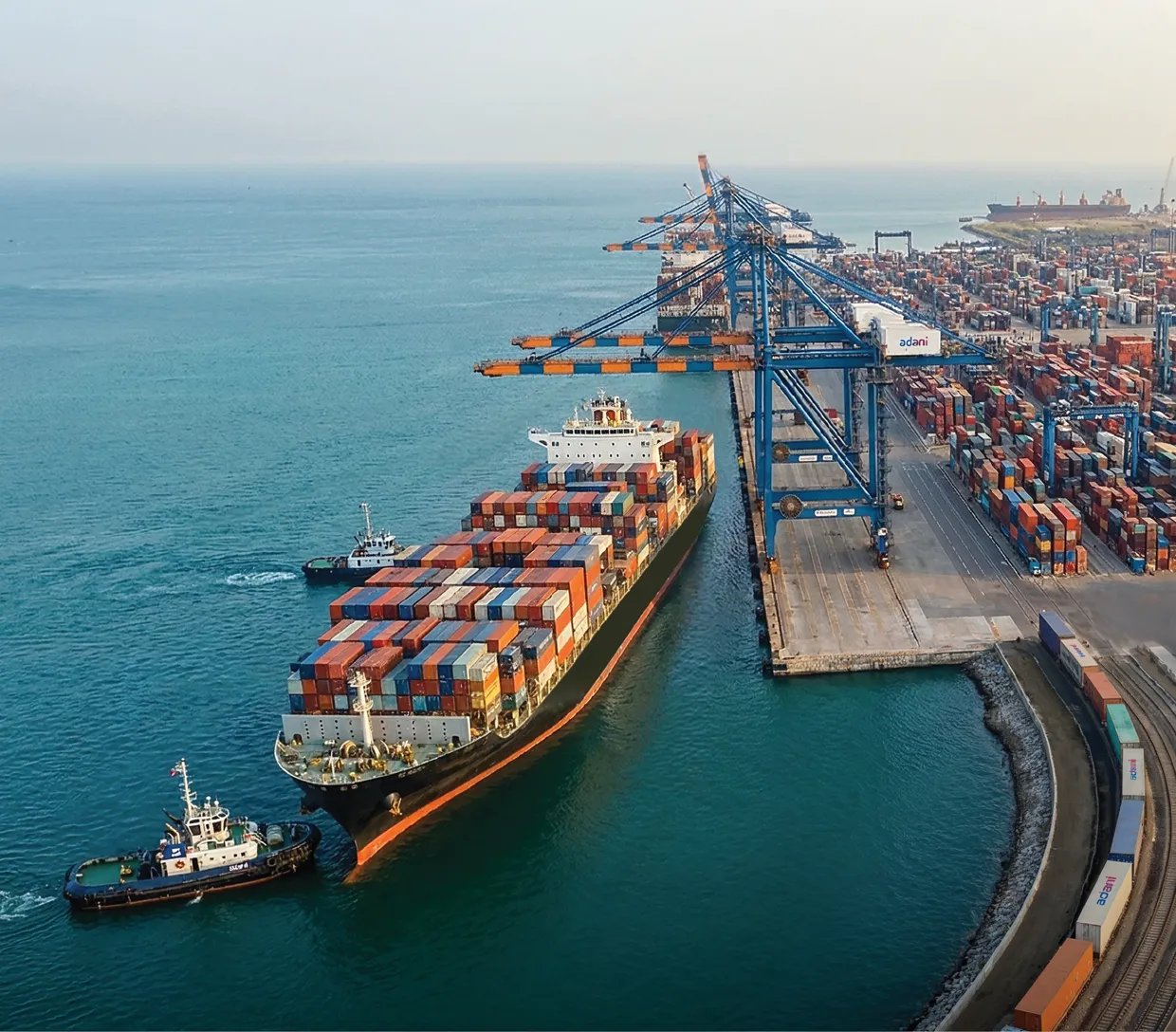 Aerial view of an APSEZ container port with cranes, vessels and logistics network