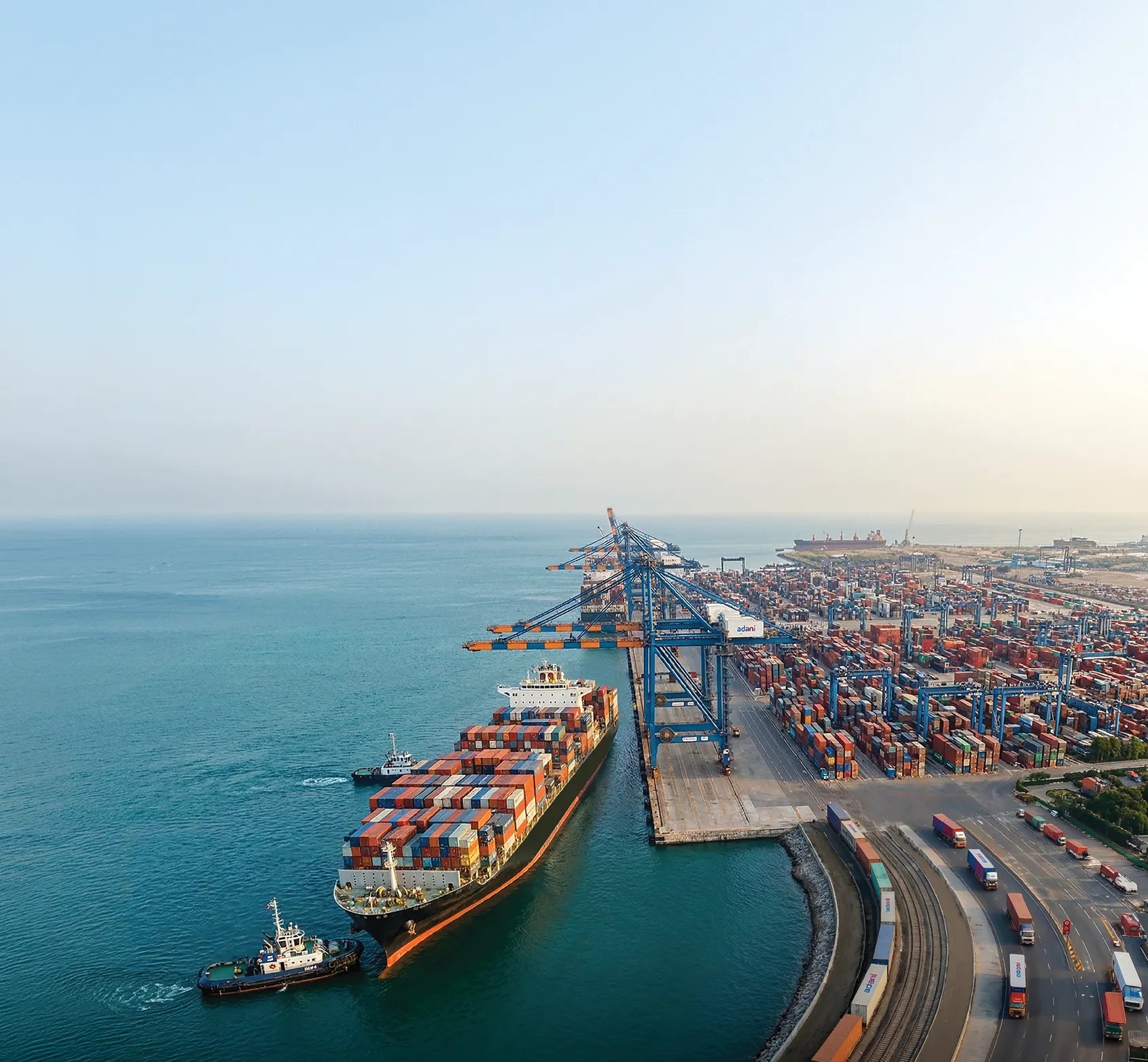 Aerial view of an APSEZ container port with cranes, vessels and logistics network