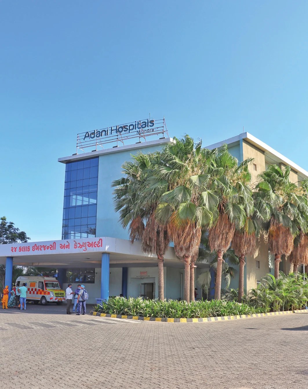 Adani Hospitals Mundra entrance with an ambulance and staff