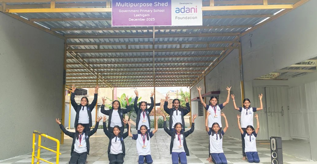 Schoolgirls celebrating under a newly built Adani Foundation multipurpose shed at a government primary school