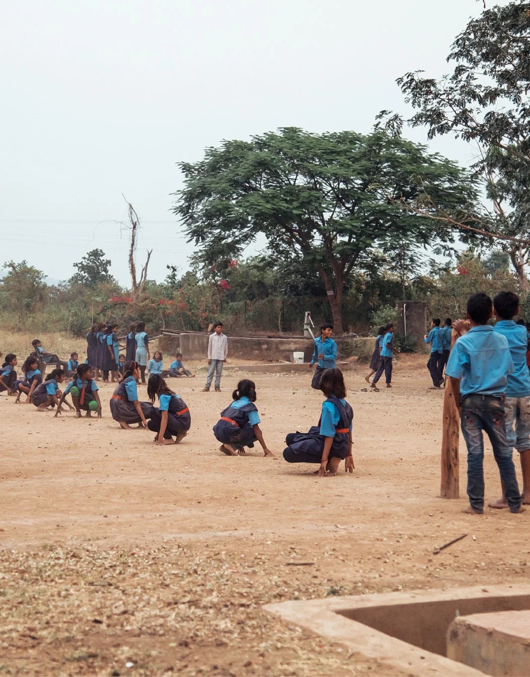 Rural schoolchildren playing kho-kho on a village ground