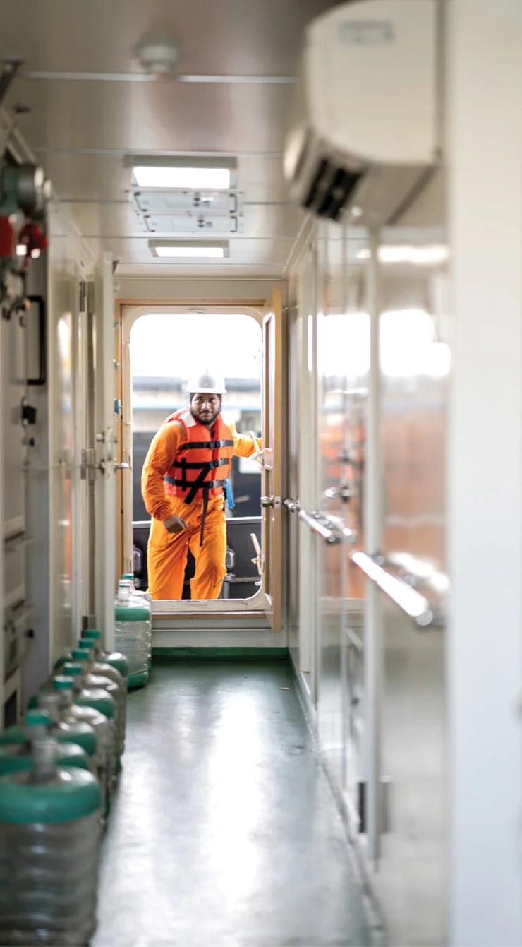Crew member in safety gear aboard an APSEZ vessel