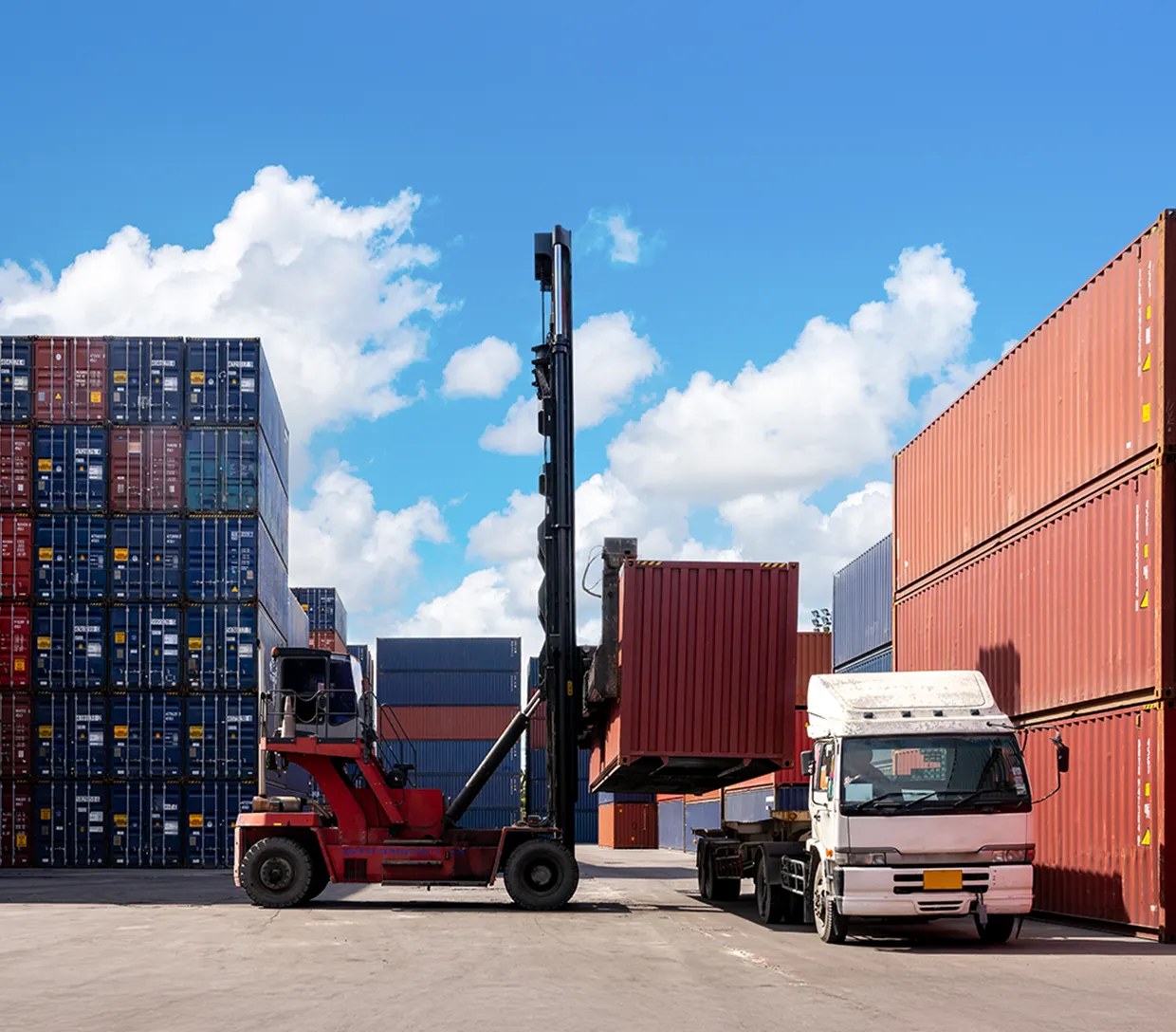APSEZ logistics yard with a reach stacker handling containers